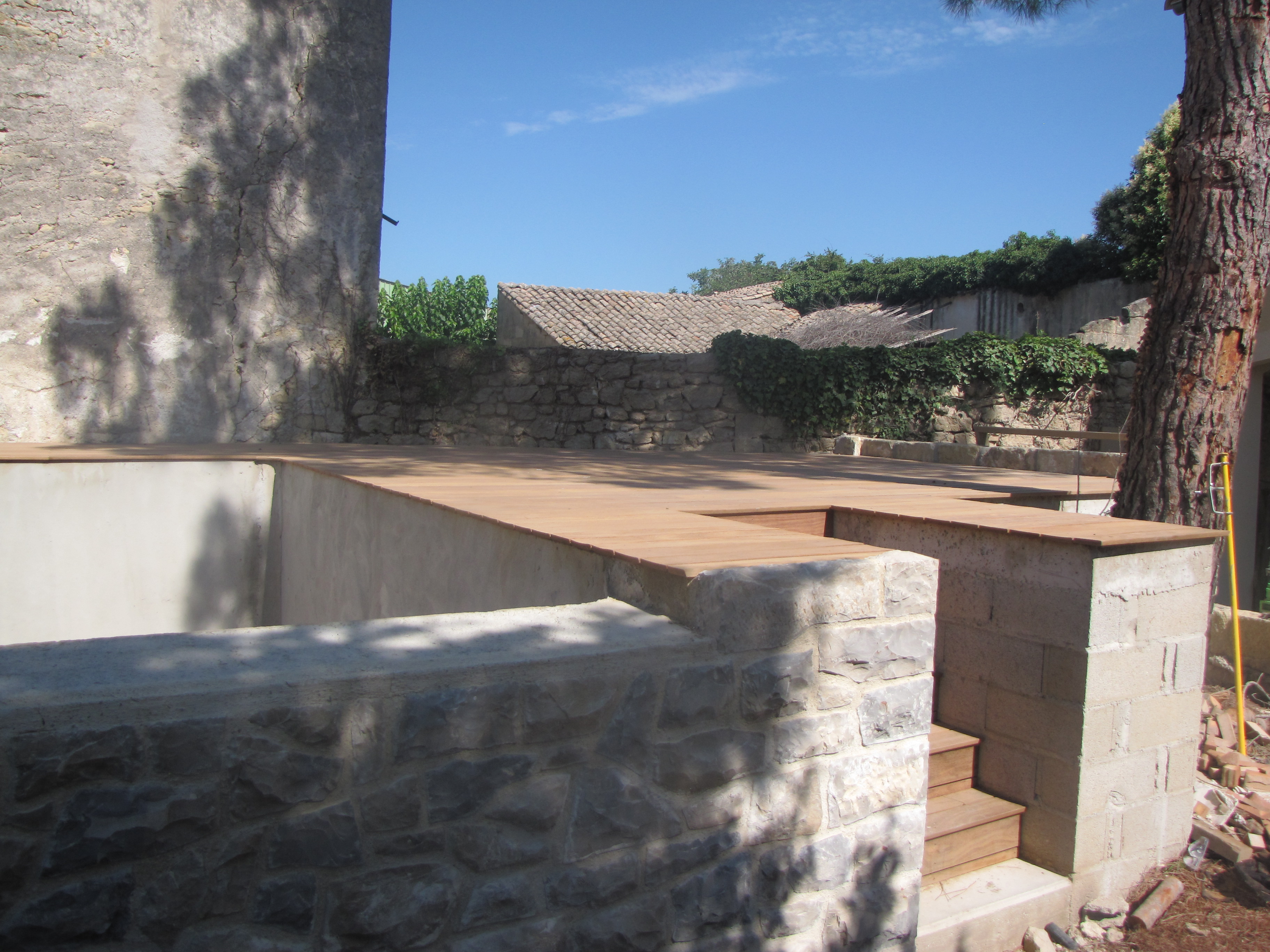 Desportes rénovation, Gard. Construction d'une piscine à débordement, habillage en pierre des extérieurs et plage en teck.