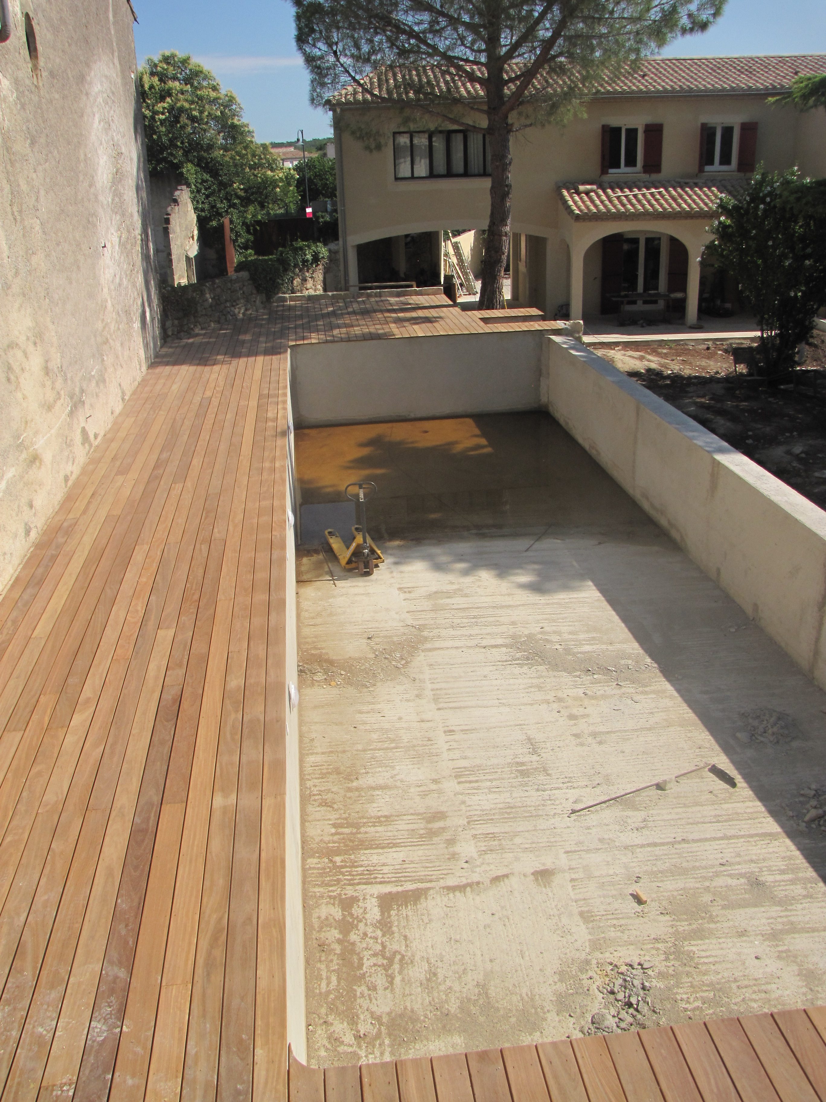 Desportes rénovation, Gard. Arase du mur du bassin pour écoulement du débordement. Plage en teck