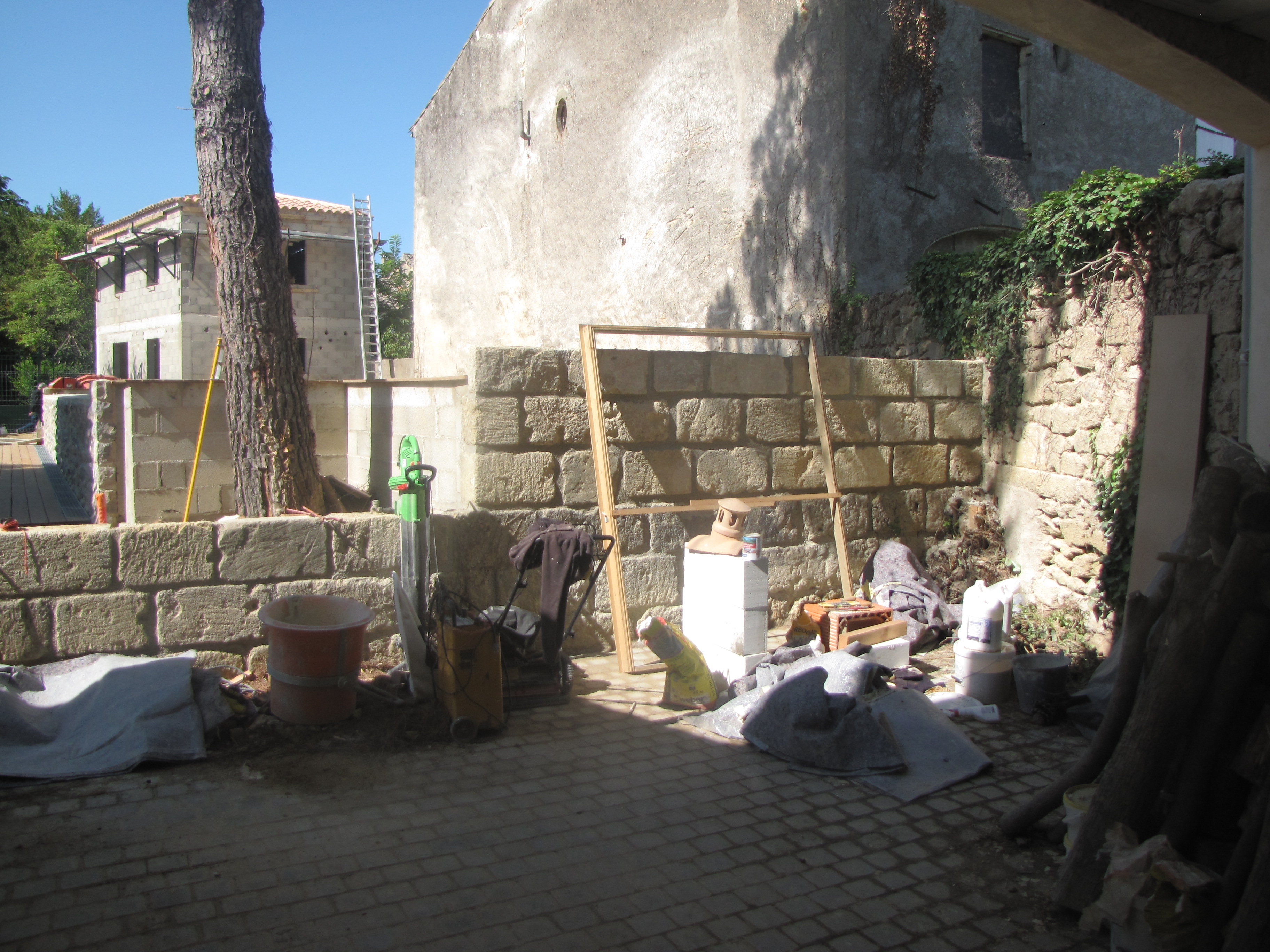 Desportes rénovation. Piscine à débordement Hérault. Habillage en pierres des murs extérieurs.